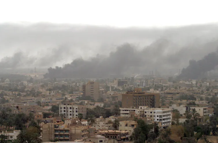Heavy smoke rises above Baghdad 08 April 2003 after coalition warplanes struck Iraqi President Saddam Hussein's Republican Palace