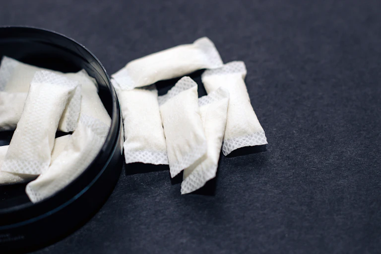 Nicotine pouches against a black background.