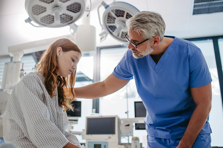 Un médecin rassure une jeune fille à l’air préoccupé.