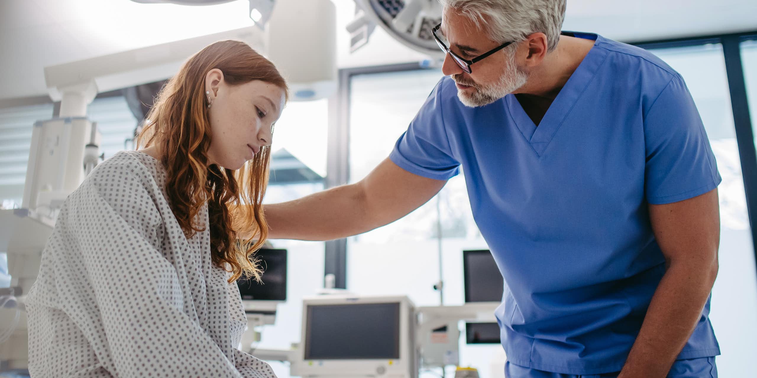 Un médecin rassure une jeune fille à l’air préoccupé.