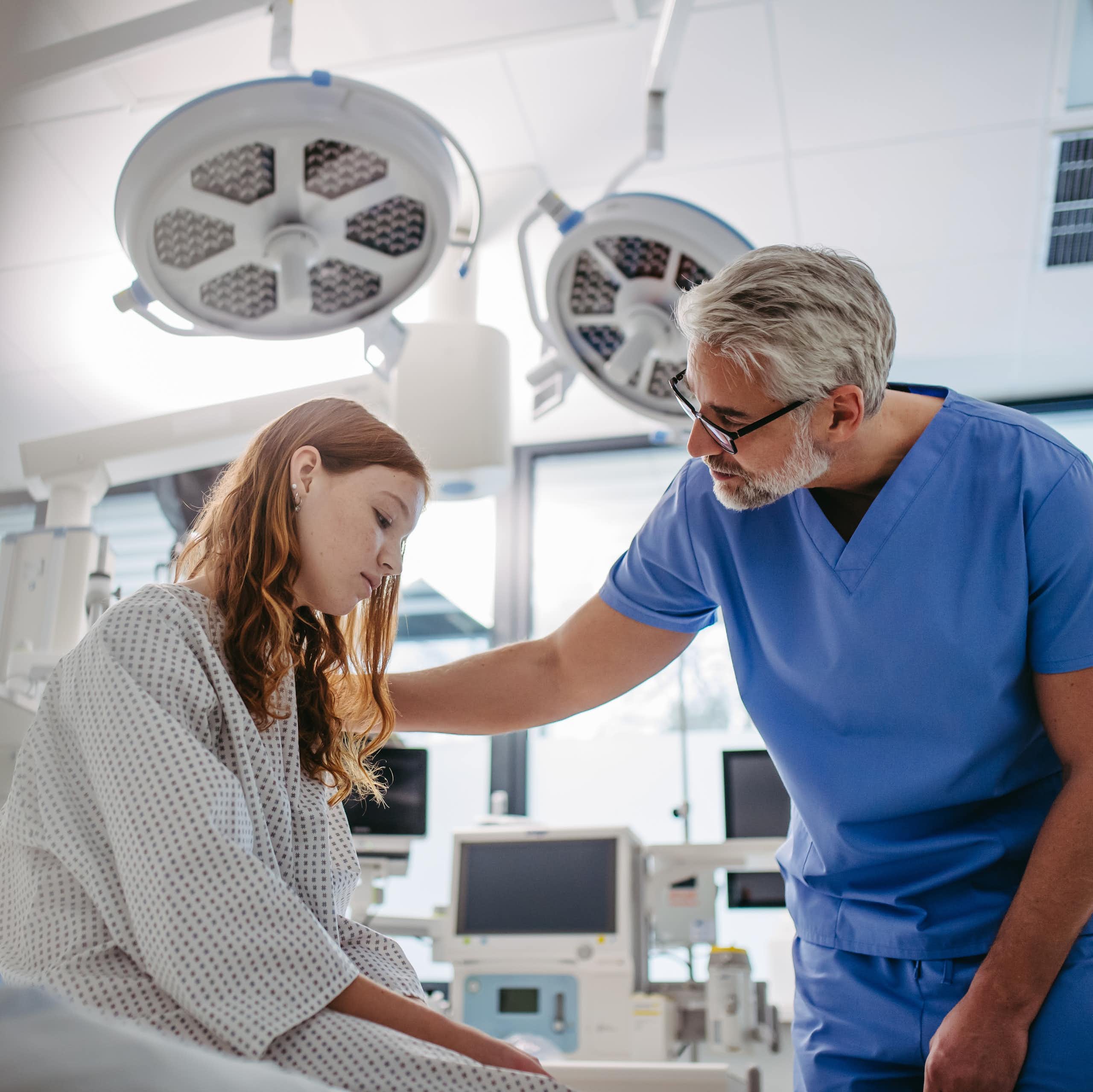Un médecin rassure une jeune fille à l’air préoccupé.