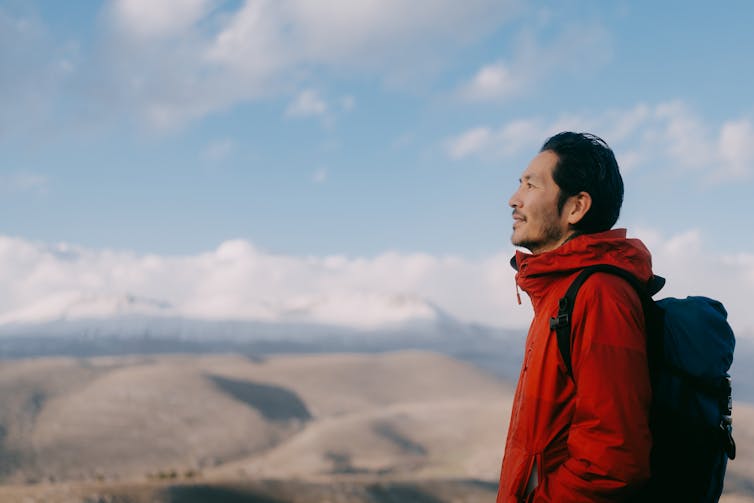 A man stands atop a mountain.