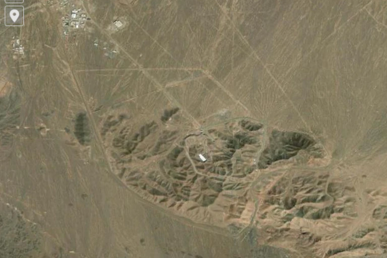 Imagen aérea de un terreno pardo con un edificio blanco en el centro