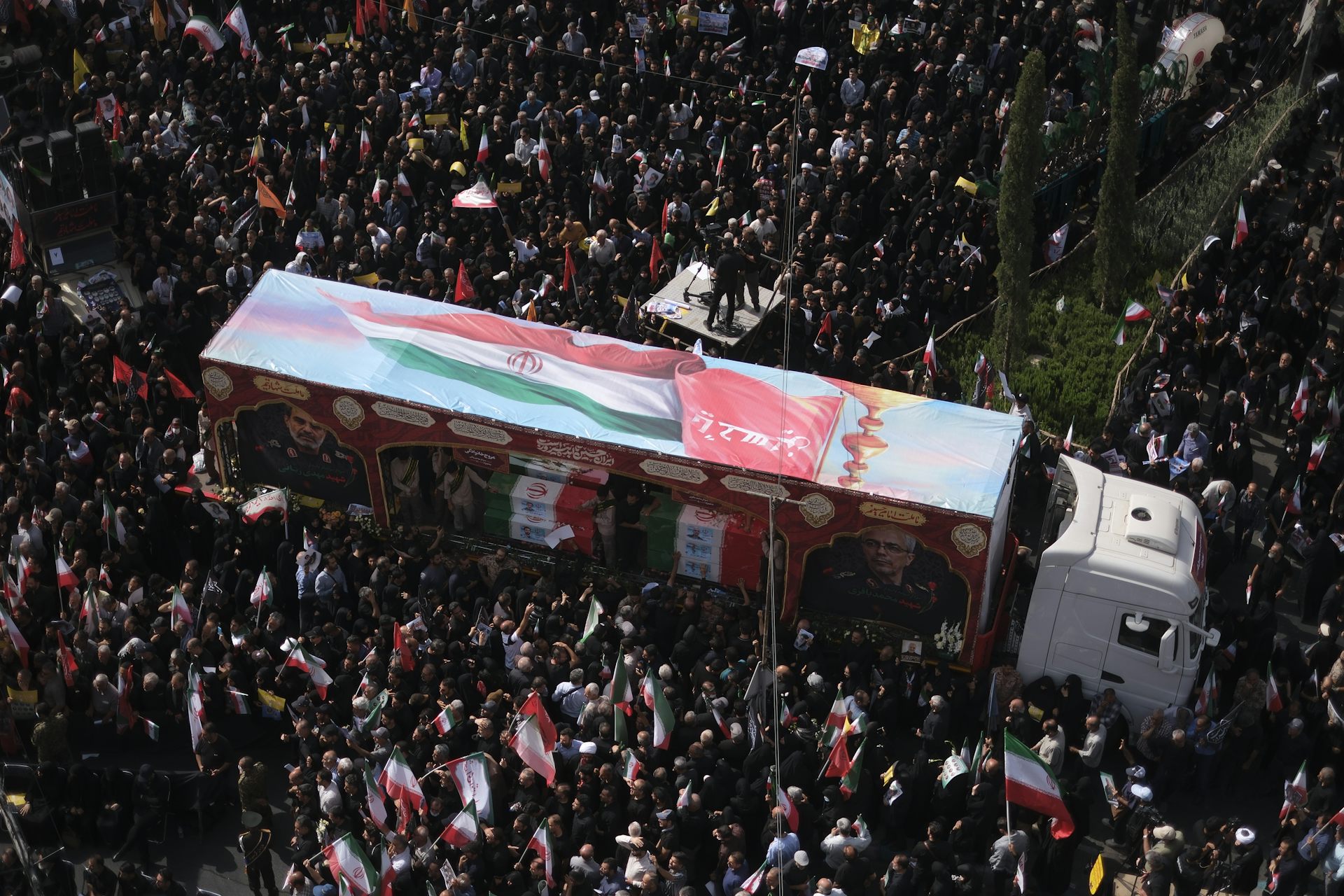 Cientos de personas rodean el camión en la plaza del pueblo.