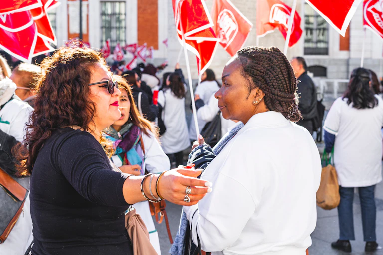 Una mujer blanca abraza a una mujer negra en una manifestación en Madrid.