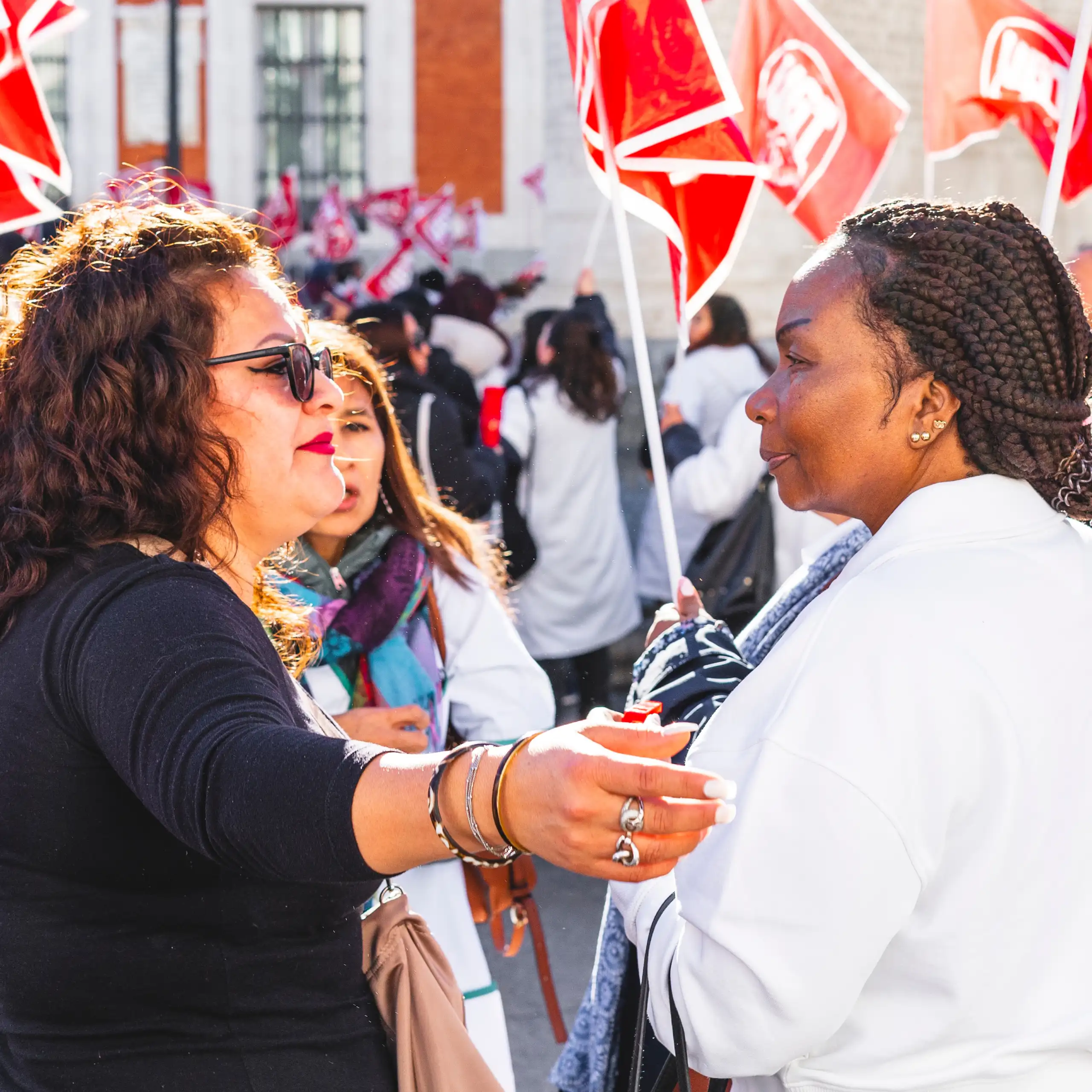 Una mujer blanca abraza a una mujer negra en una manifestación en Madrid.