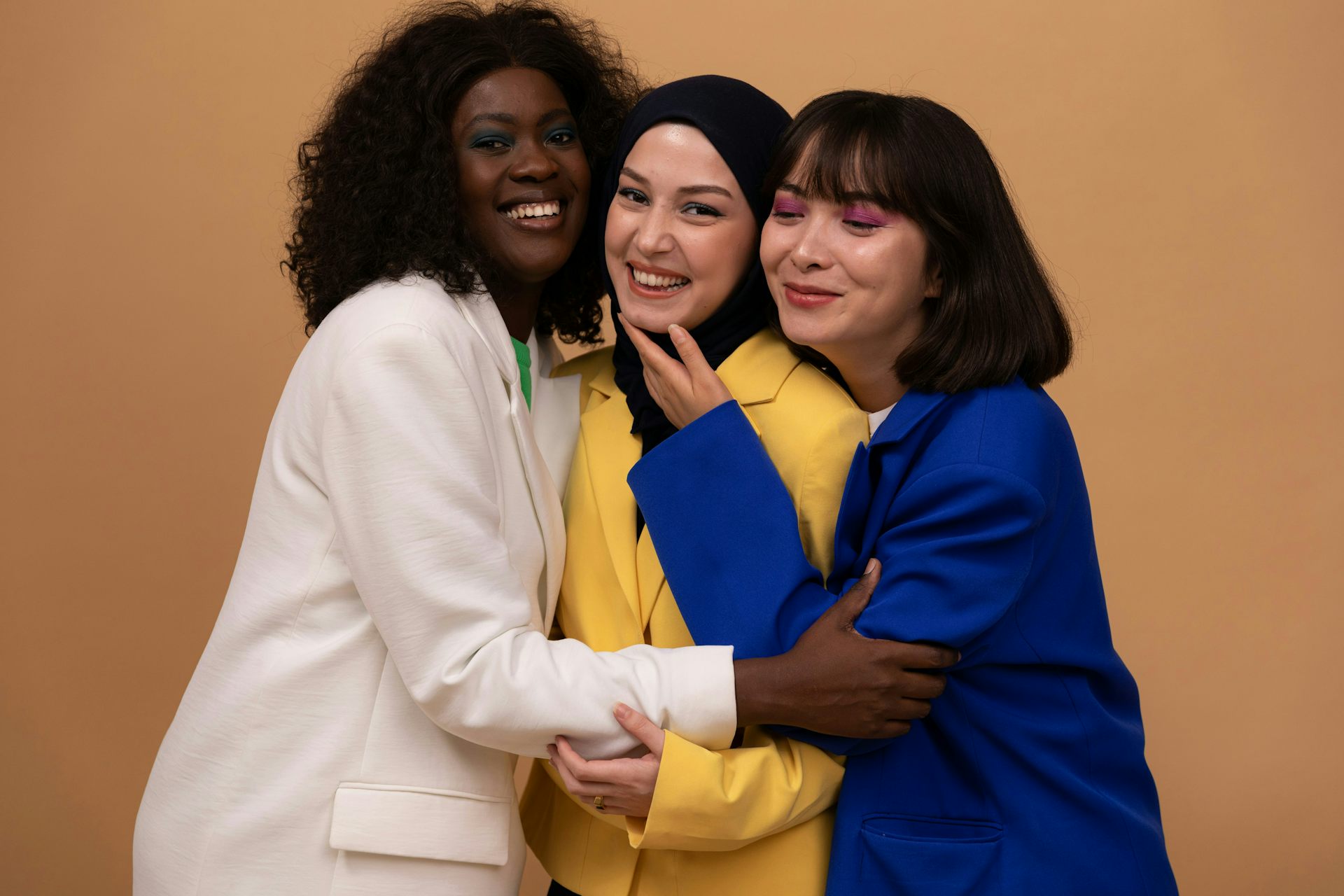 Three women hugging each other and smiling.