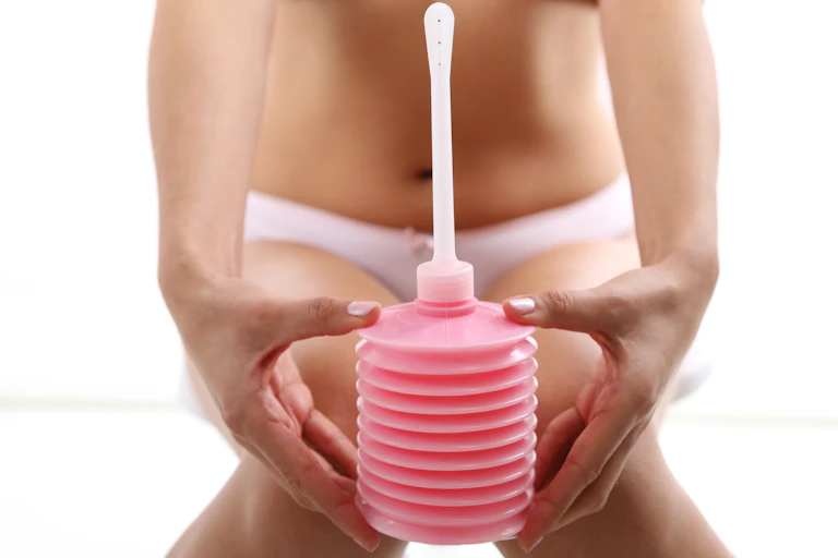 Close up of woman holding a vaginal douche