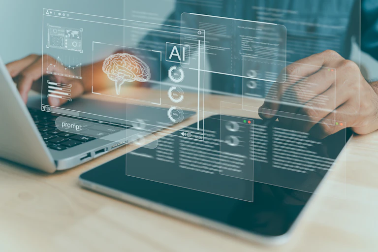 A person is seen working at a laptop with images projecting that show a brain and say AI