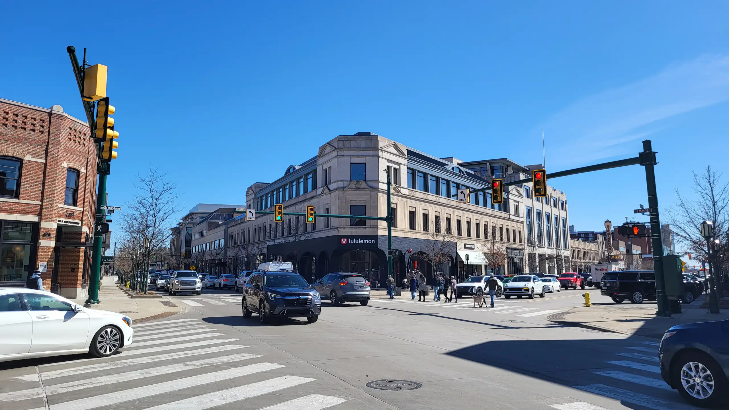 Cars drive on street in a downtown district.