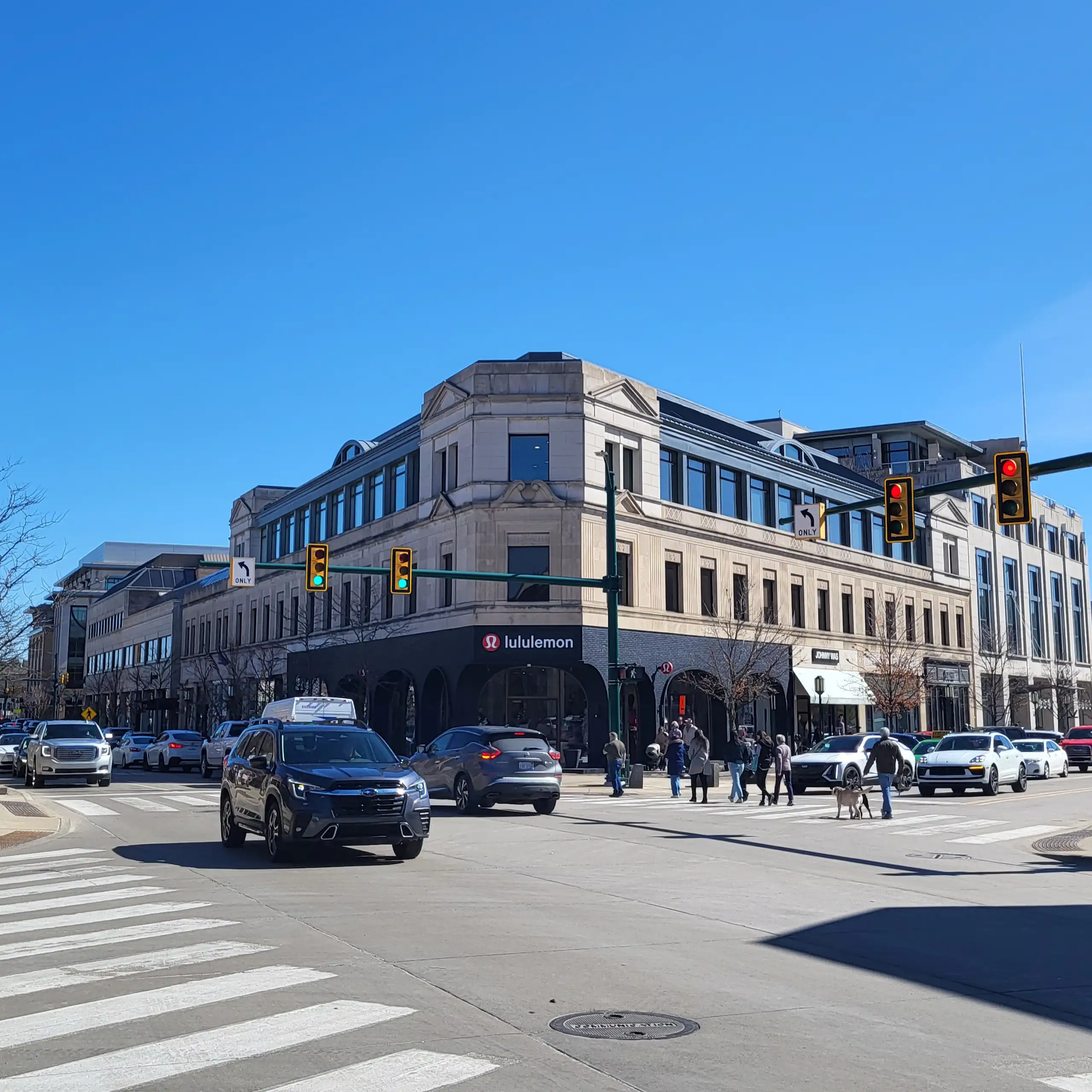 Cars drive on street in a downtown district.