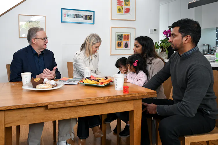 Albanese, prime minister, at a kitchen table with a young family.