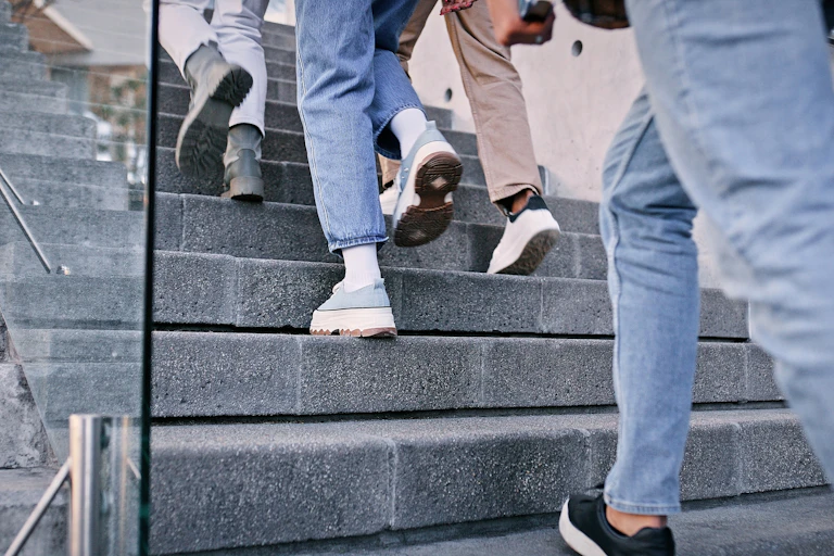 Gros plan sur des pieds qui montent l'escalier.
