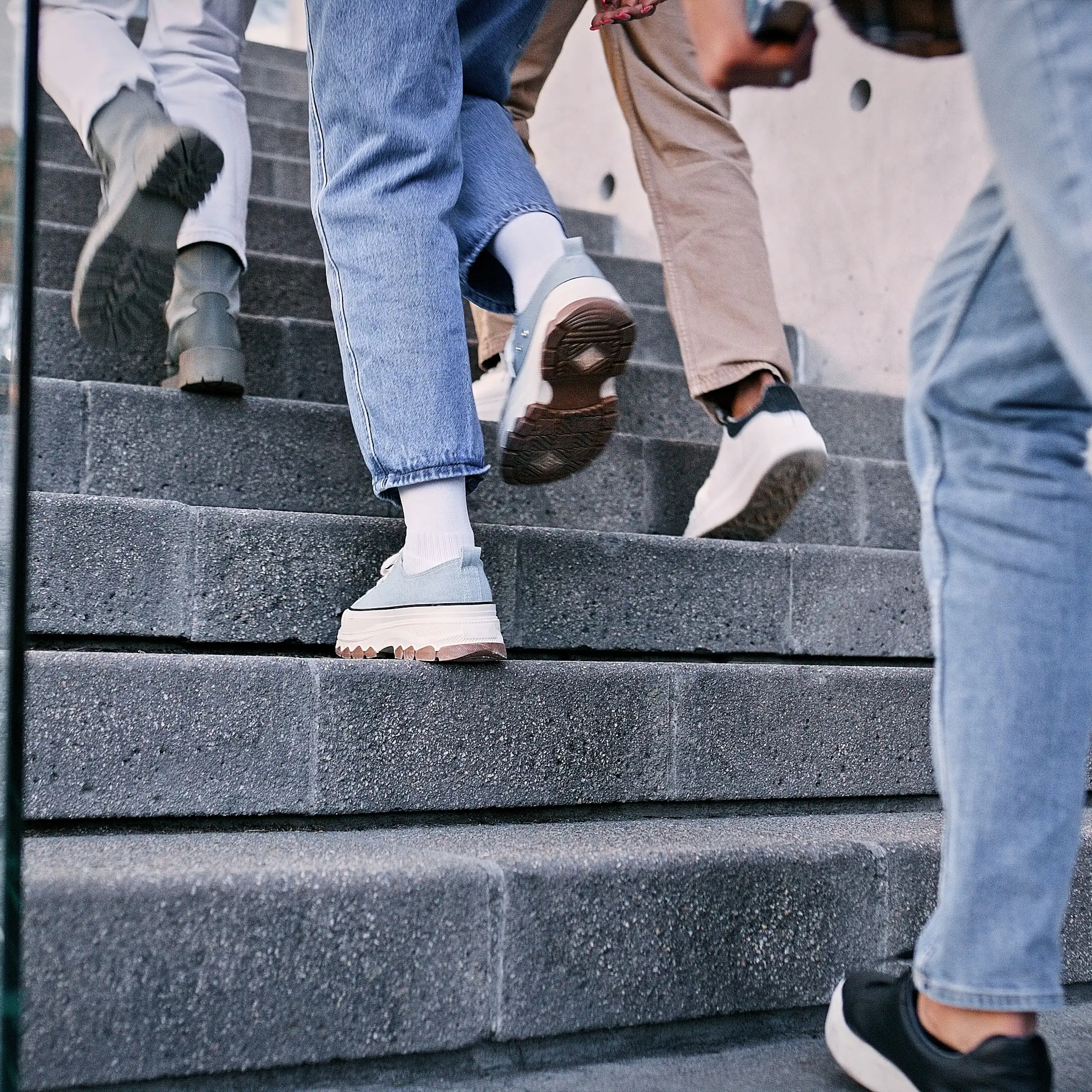 Gros plan sur des pieds qui montent l'escalier.