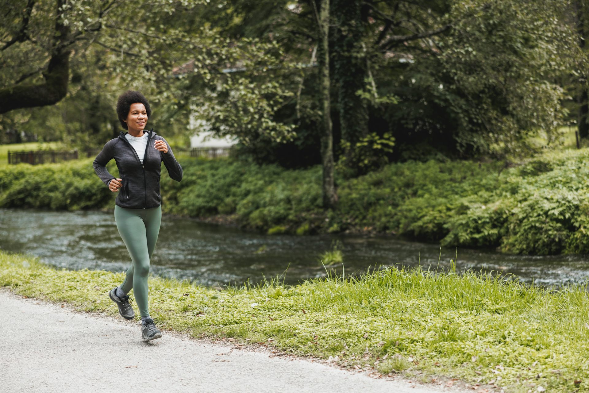 A woman goes for a jog in a park.