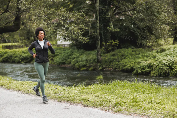 A woman goes for a jog in a park.