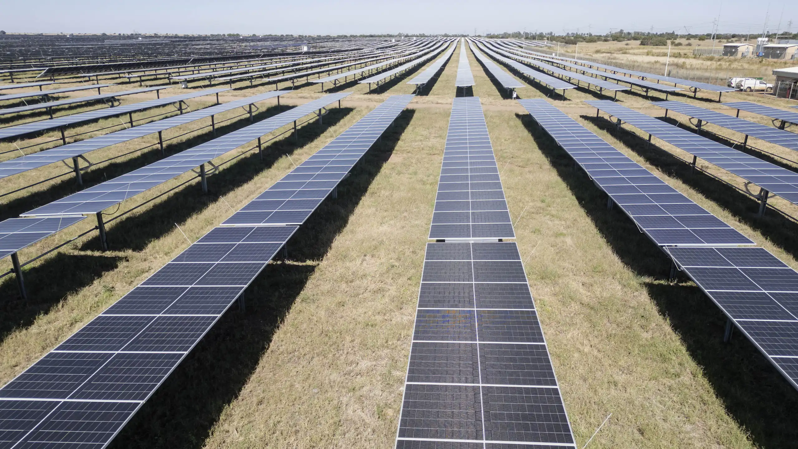 Lines of solar panels stretching across the ground about 20 soccer fields big