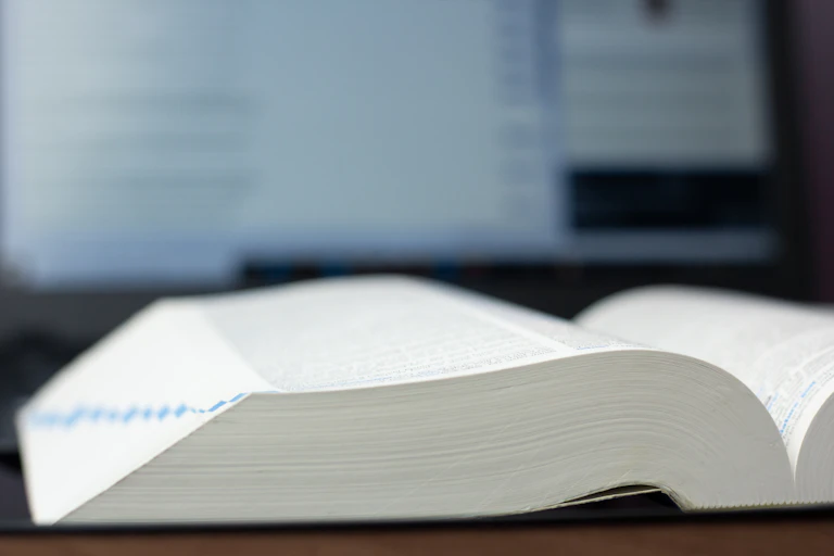 Un llibre en paper, gros, obert per la meitat