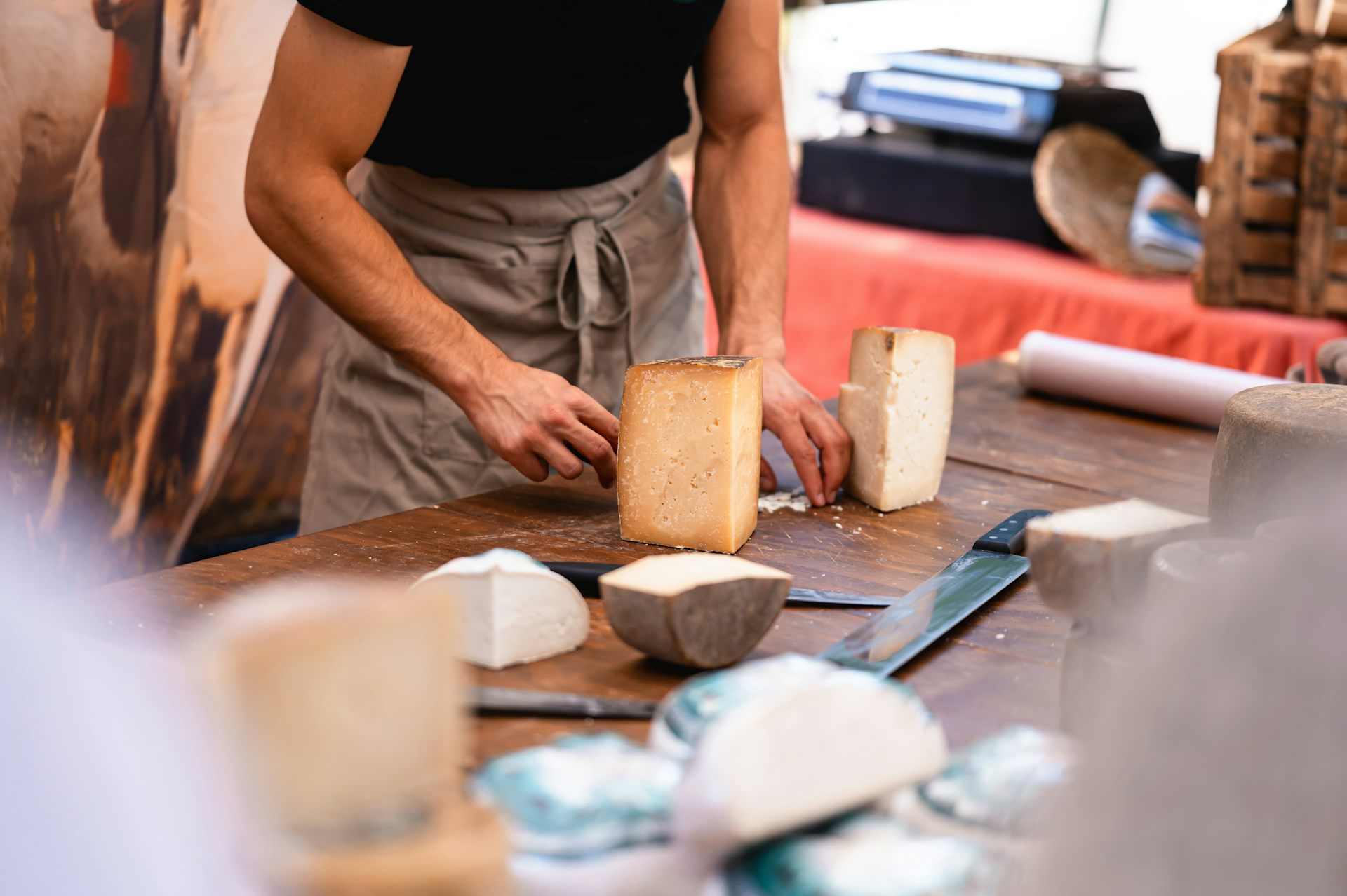 Una persona amb un davantal tallant formatge