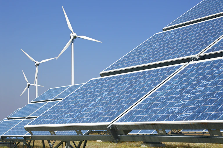 Solar panels with wind turbines in the backdrop
