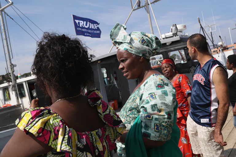 Several people walk at a marina.