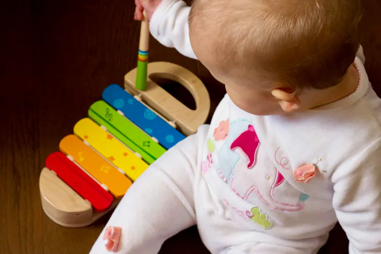 A baby plays with a xylophone.