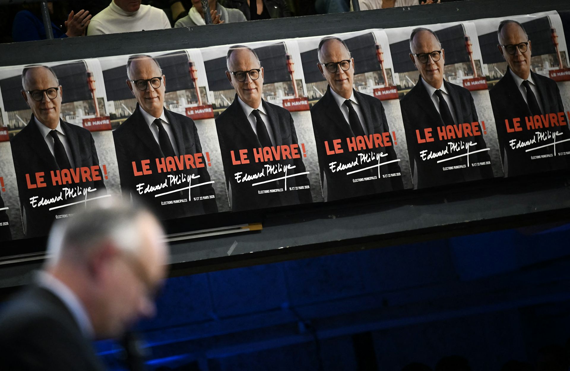 Affiches électorales devant lesquelles passe Edouard Philippe (flouté) 