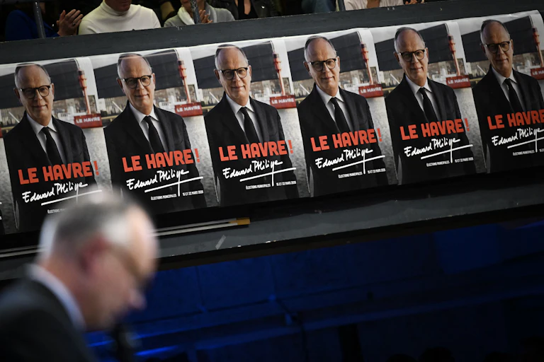 Affiches électorales devant lesquelles passe Edouard Philippe (flouté)