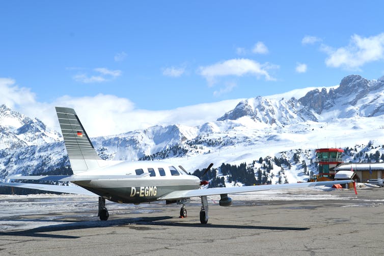 small private jet on runway in snowy mountains