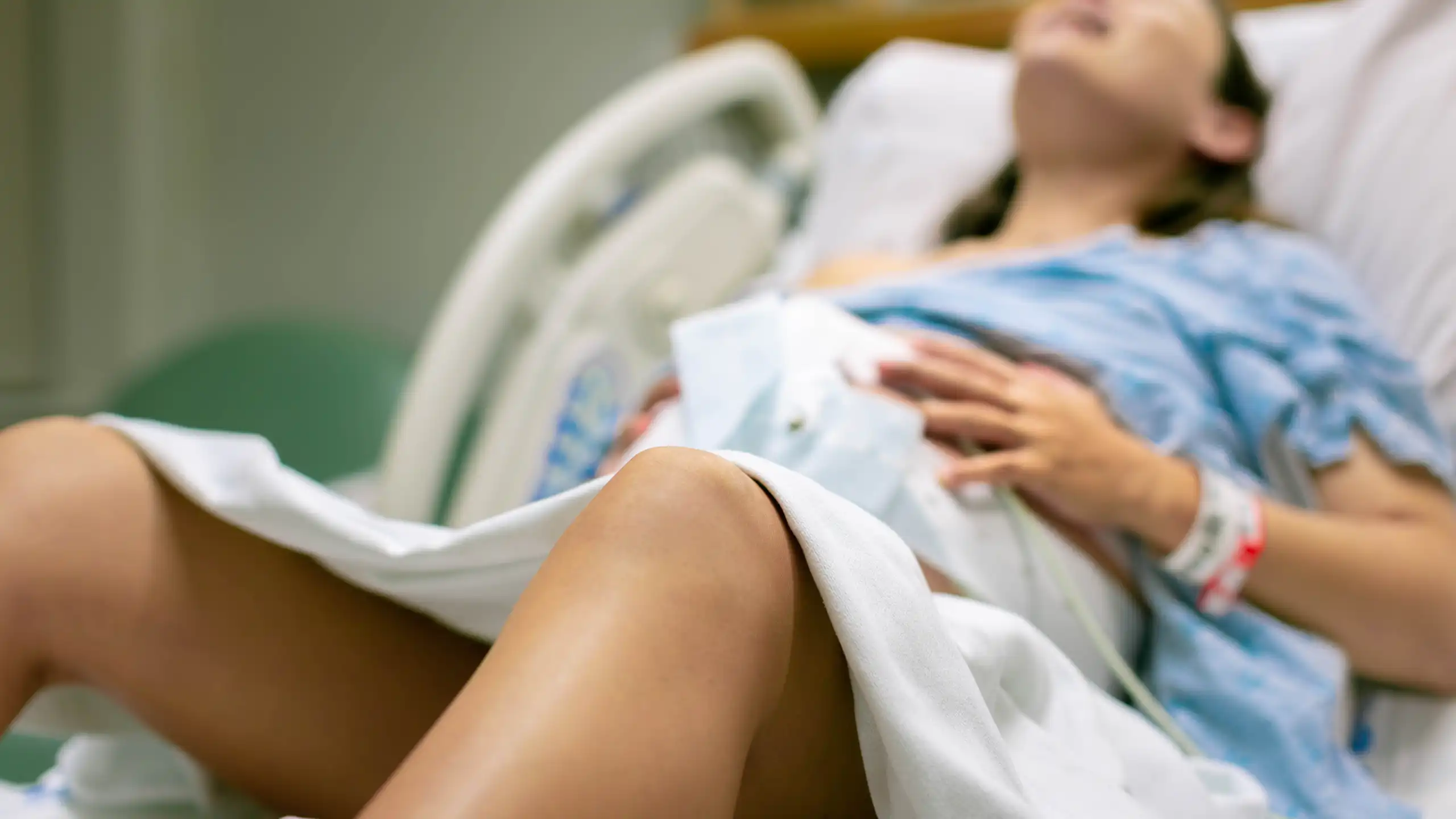Una dona parint al llit d'un hospital.