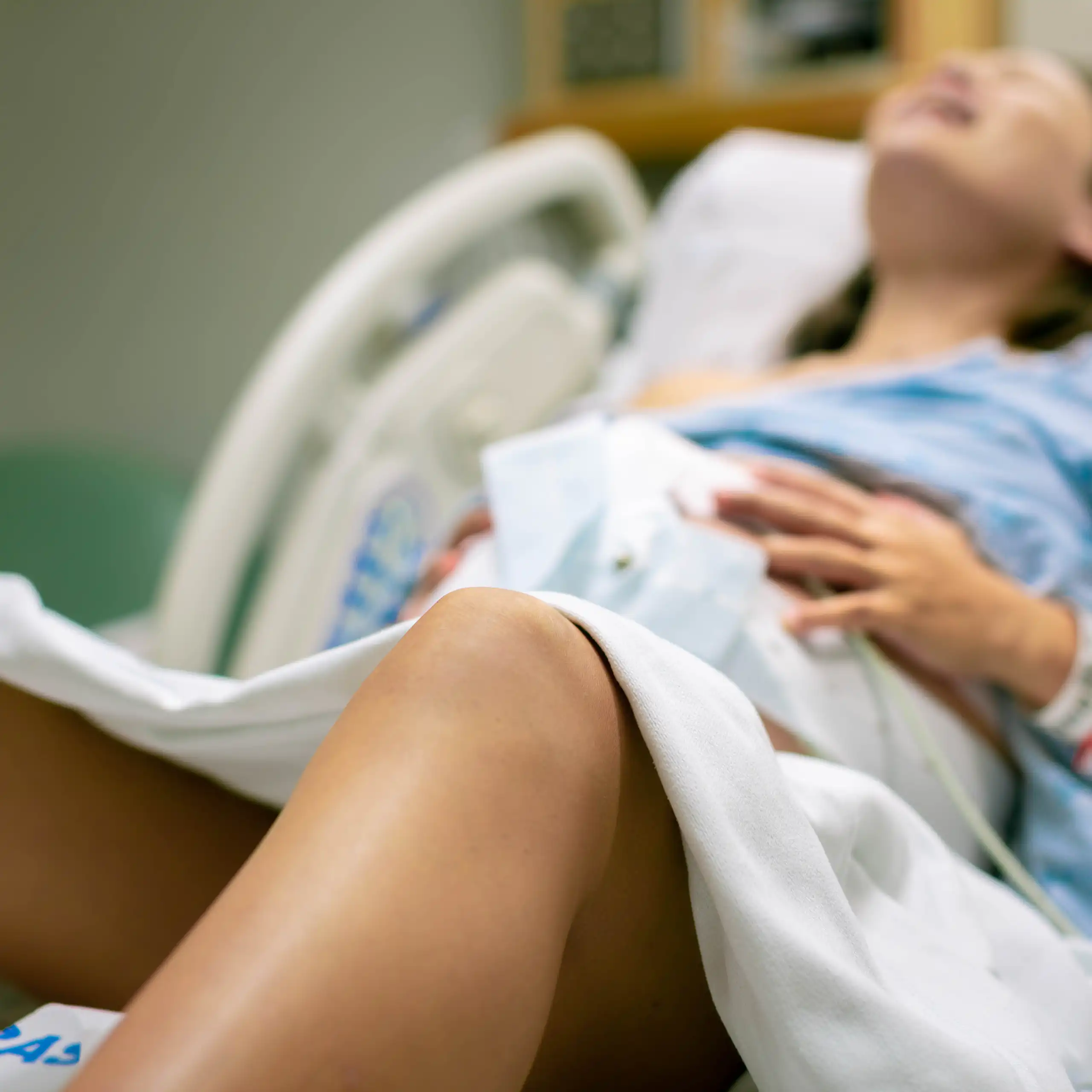 Una dona parint al llit d'un hospital.