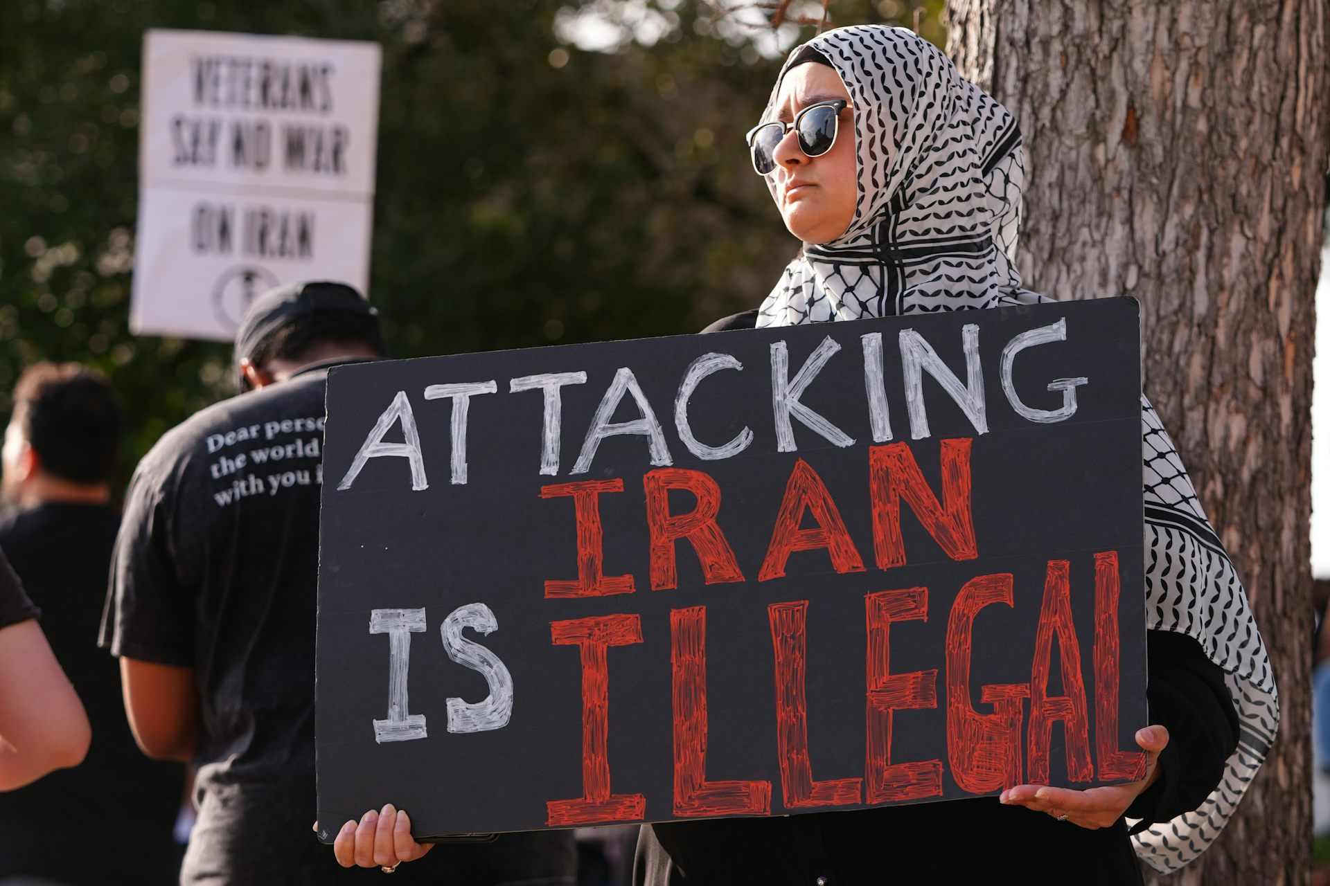 Una mujer sostiene un cartel de protesta.