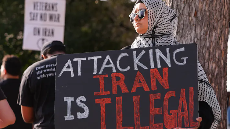 A woman holds a sign in protest.