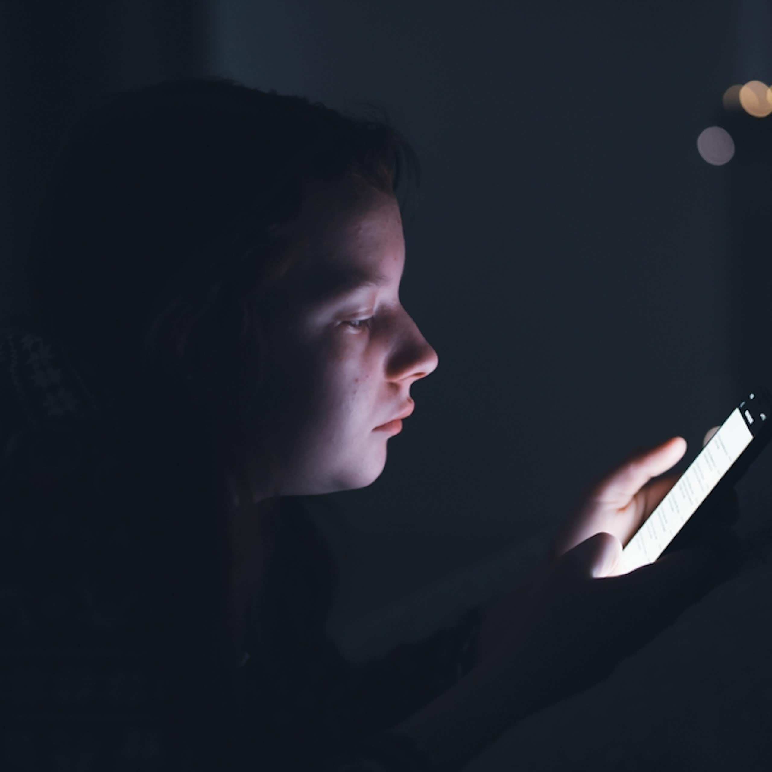 Une adolescente en train de consulter un smartphone.