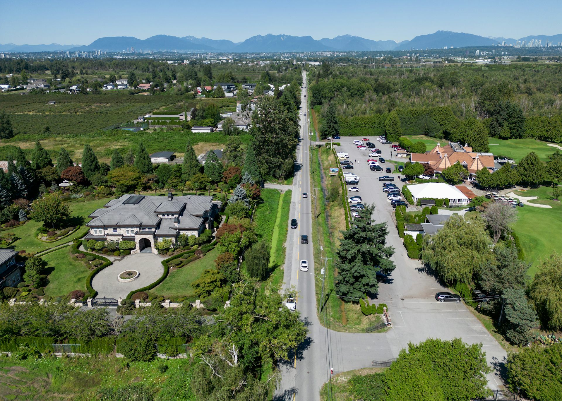 Vista aérea del suburbio que muestra una casa grande y un campo de golf.