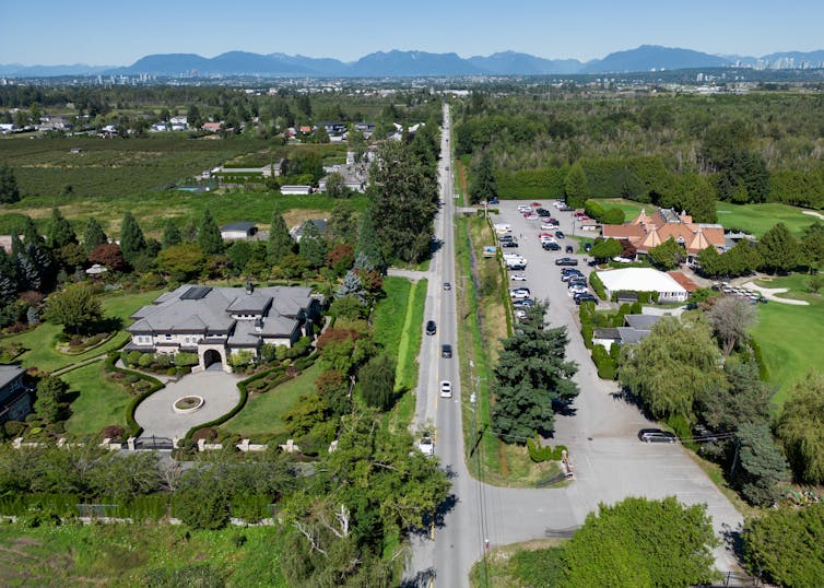 Vista aérea del suburbio que muestra una casa grande y un campo de golf.