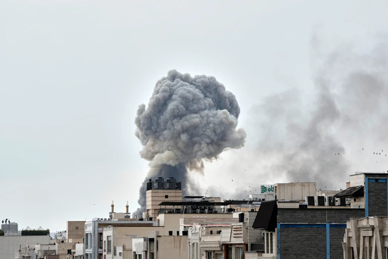 A plume of smoke rises from a city that has been attacked.