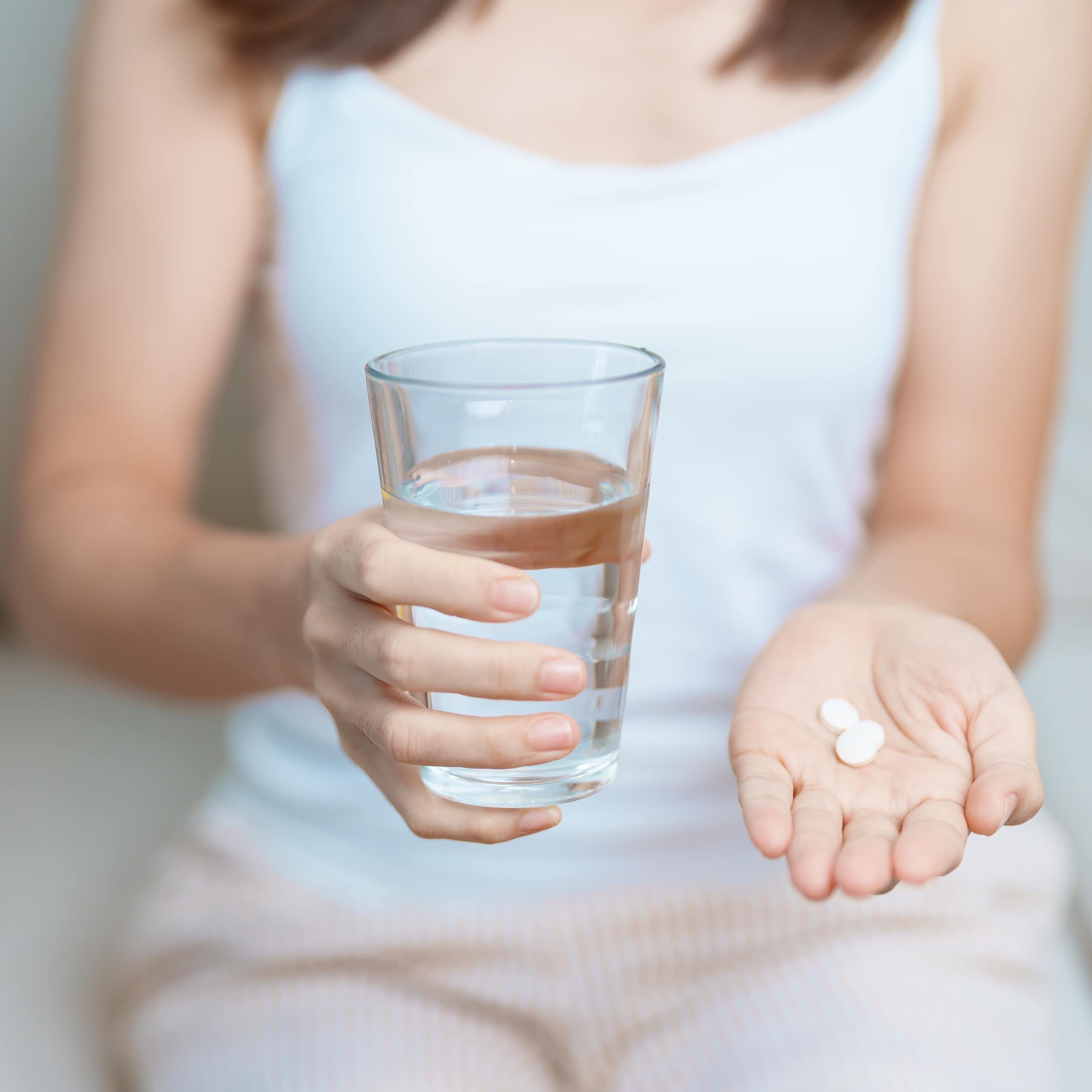 Una mujer muestra una pastilla en la mano