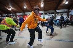 La gente baila en una reunión pública.