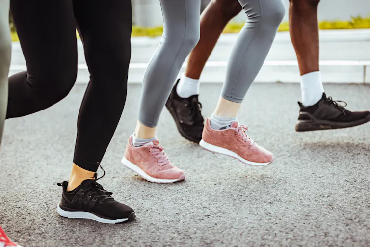Close-up of legs of three people running