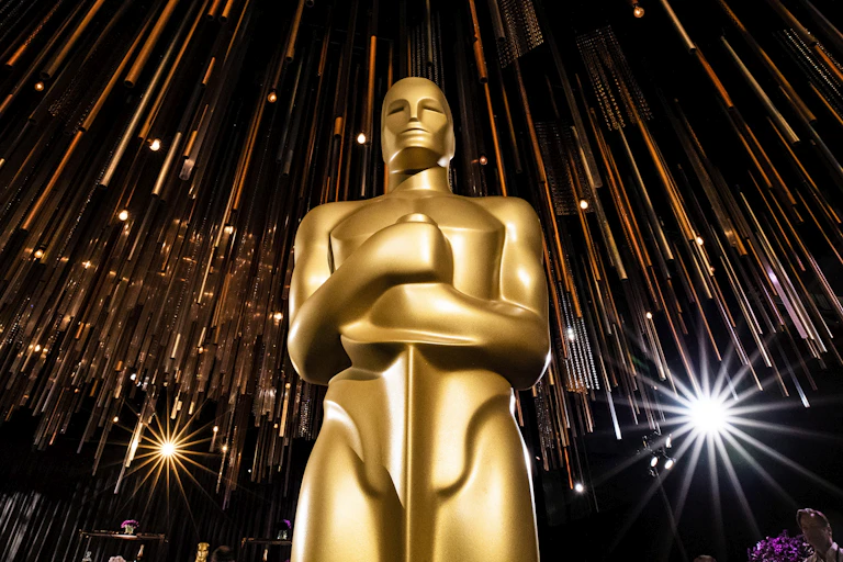 A low-angle view of a giant statue of the golden Oscar trophy.