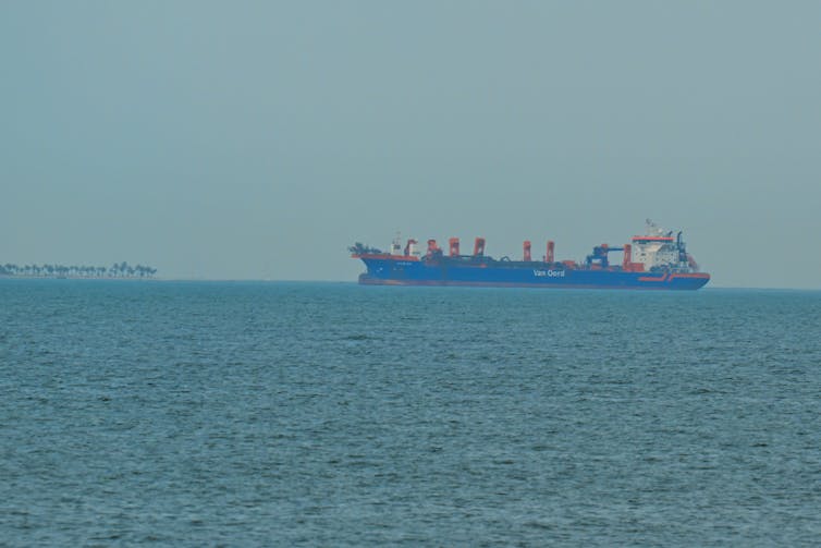 Large commercial ships anchor off the coast of the United Arab Emirates.