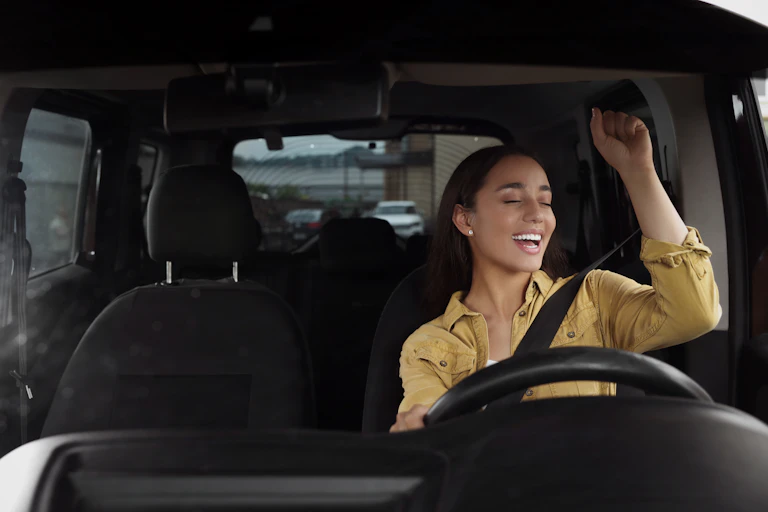A young woman singing in the car.