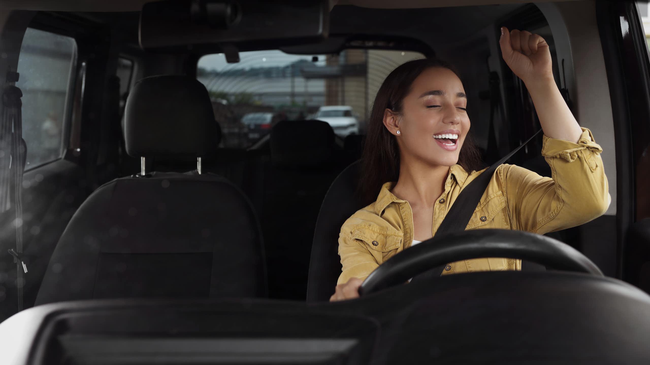 A young woman singing in the car.