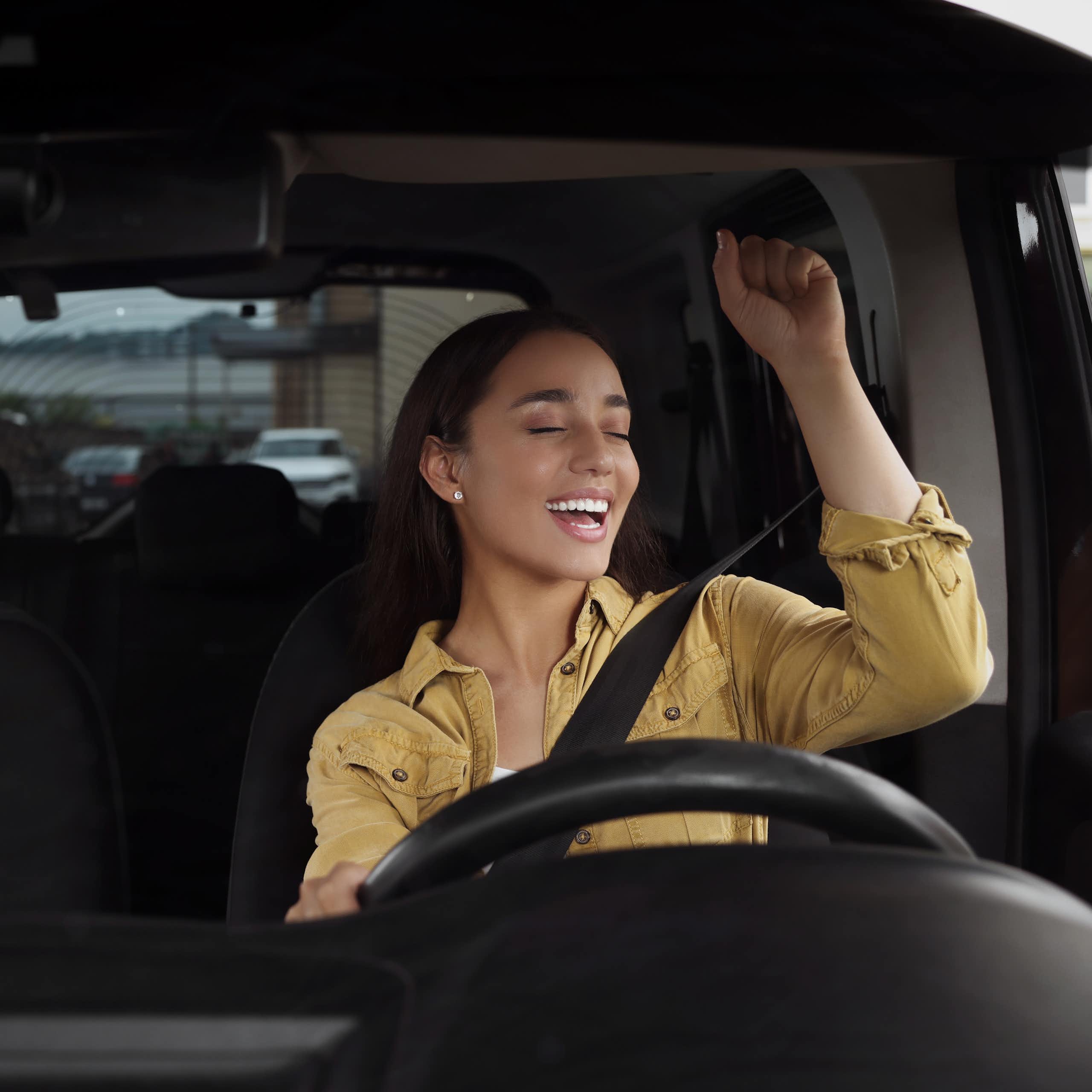 A young woman singing in the car.