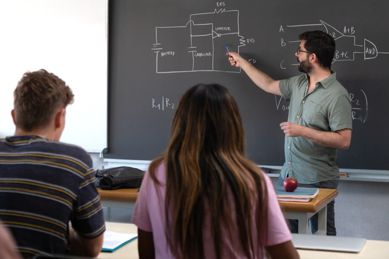 Un profesor señala en una pizarra