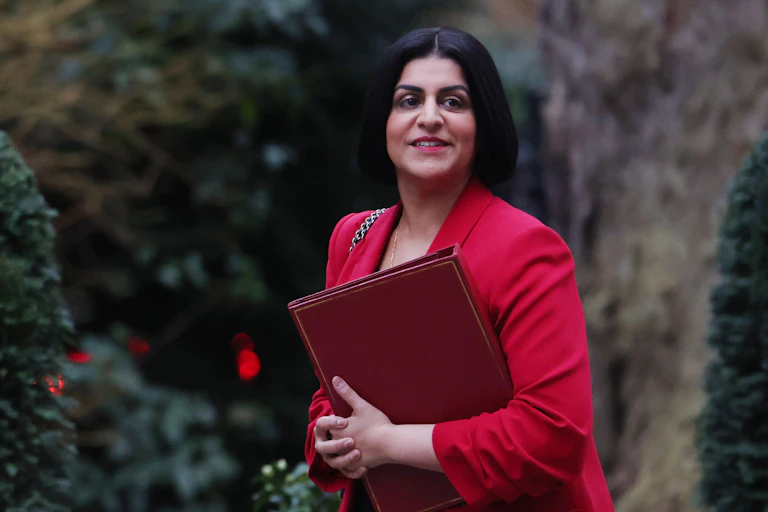 Home secretary Shabana Mahmood walking with a red folder