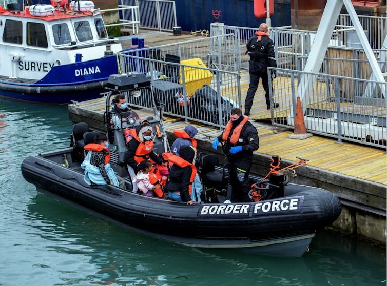 A border force boat carrying people thought to be refugees arrives at a dock in Dover