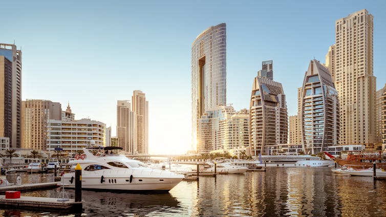 Boats in marina surrounded by skyscrapers.