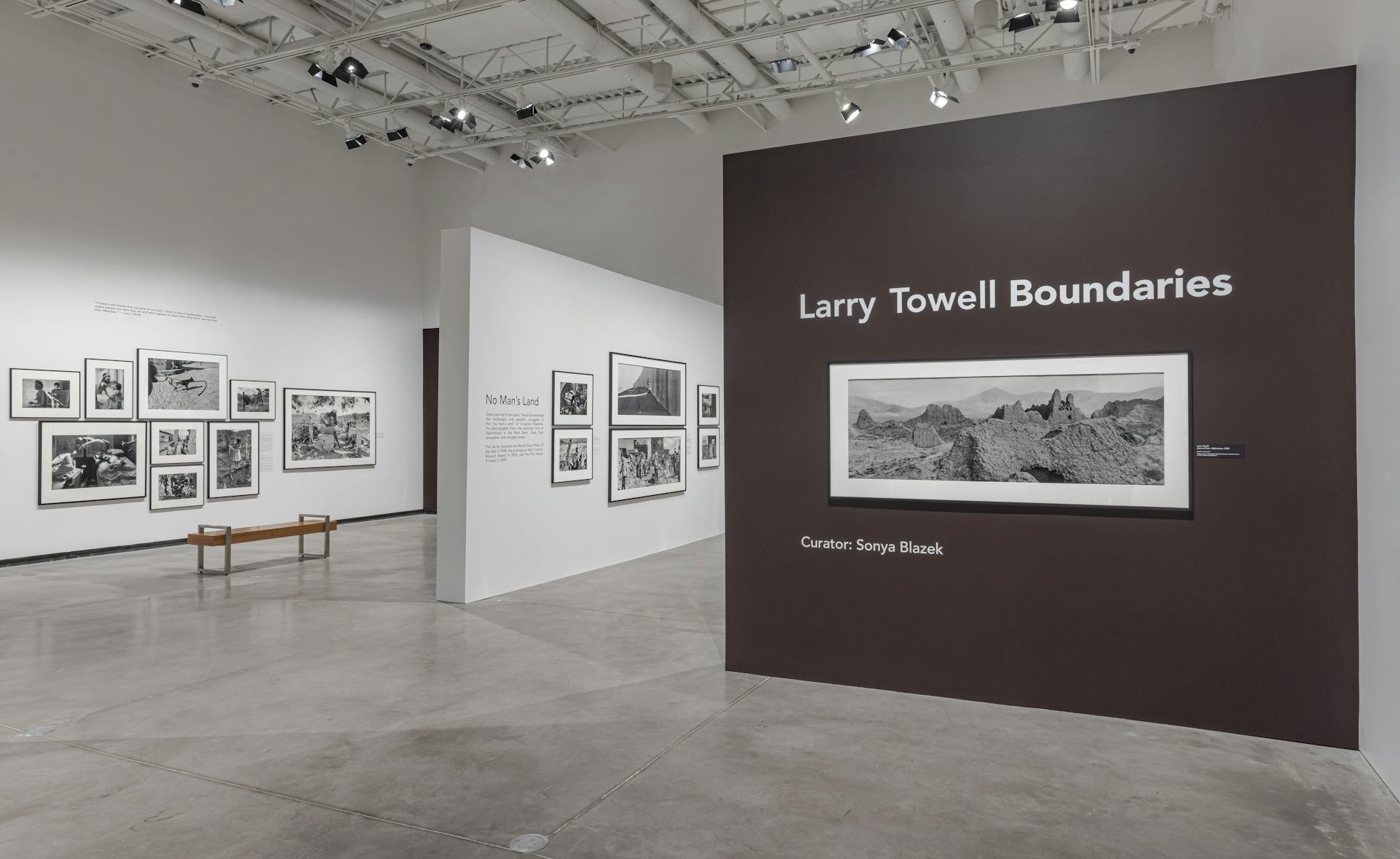 Toma horizontal larga de un paisaje rural contra una pared que dice Larry Tovell Boundaries.